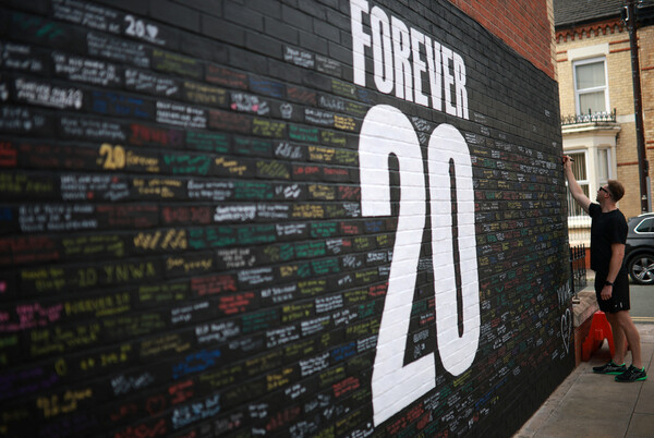 Liverpool fan is writing a memorial article on the Dogu Steering Memorial Wall, which is located near Anfield Stadium, the homeste. Liverpool/Reuters Yonhap News