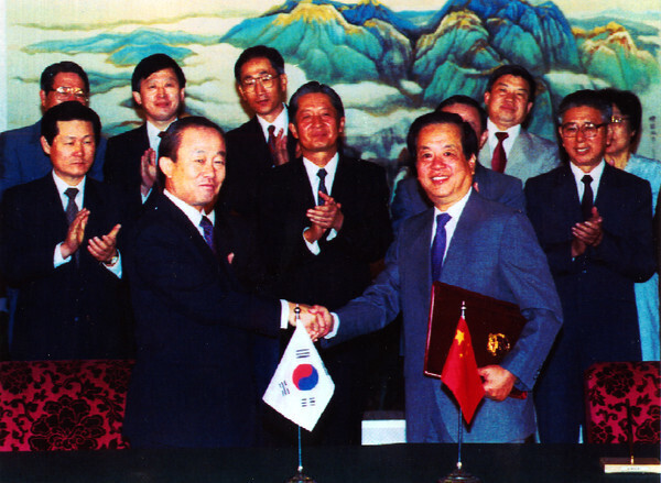Lee Sang-ok (right), South Korea’s foreign minister at the time, shakes hands with Qian Qichen, China’s foreign minister, following the signing of a joint statement on the establishment of diplomatic relations between their two countries in Beijing, China, on Aug. 24, 1992. (Yonhap)
