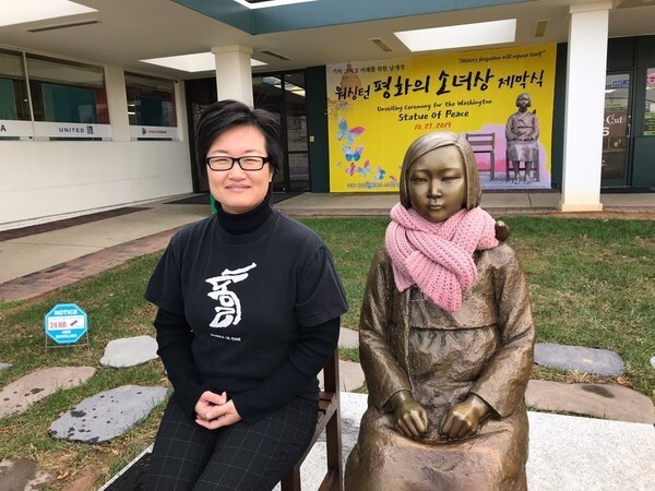 Hyunsook Cho, president of Washington Butterfly for Hope, poses next to the comfort woman statue in Annandale, Virginia. (provided by Hyunsook Cho)