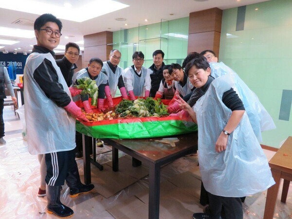 South and North Korean staffers at the Inter-Korean Liaison Office make kimchi together using cabbages from their communal field. (provided by Park Jin-won)