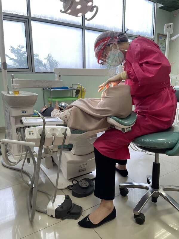 Maria tends to a patient at a dentist’s office in Jakarta, Indonesia, in October 2023. (courtesy of Maria)