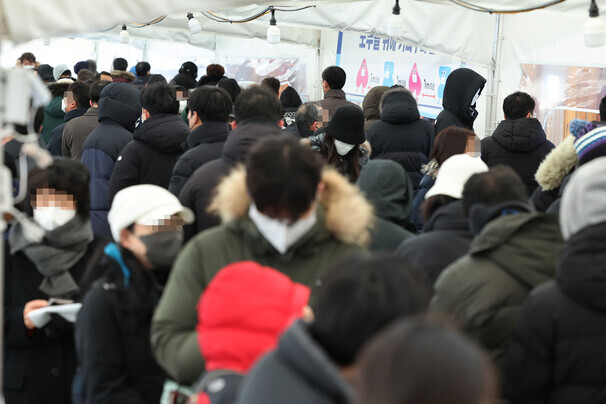 People wait in line at a COVID-19 screening station in Seoul’s Songpa District for rapid antigen tests. (Yonhap News)