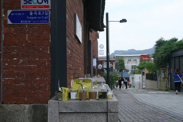 A sign made by a Bukchon resident laments at how the city of Seoul has converted the neighborhood into a tourist attracting that provides no benefits to the people who live there.