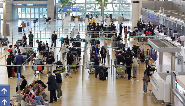 Travelers wait in lines for boarding procedures at Terminal 1 of Incheon International Airport on April 22. (Yonhap News)