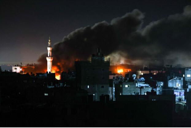 팔레스타인 가자지구 라파흐에 12일 새벽 이스라엘군이 대대적인 공습을 가해, 폭격당한 건물에서 화염이 치솟고 있다. AFP 연합뉴스