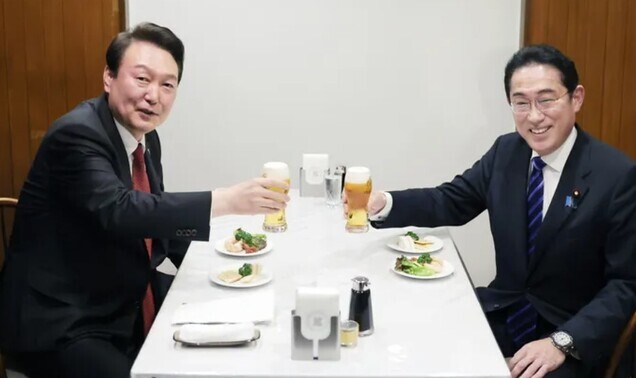 South Korean President Yoon Suk-yeol (left) and Japanese Prime Minister Fumio Kishida raise their glasses of beer for a toast at a meal during Yoon’s trip to Tokyo for a summit in March 2023. (Yonhap)