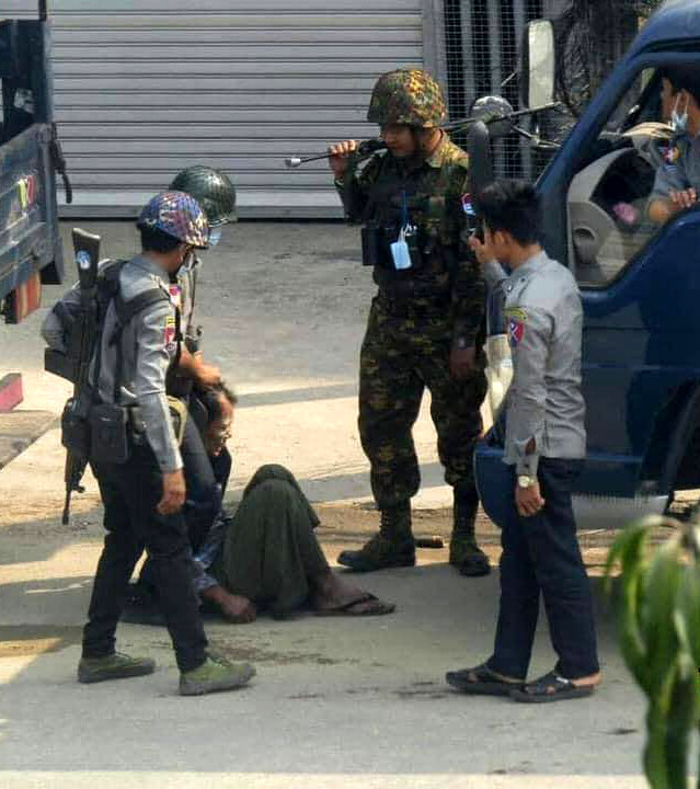 무장한 군인들이 3월19일 시민의 목에 밧줄을 걸어 당기고 있다.
