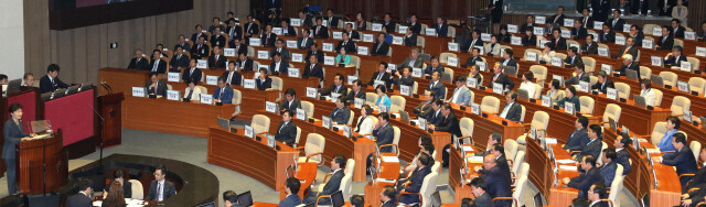 Opposition lawmakers affix messages opposing state-issued history textbooks and calling on President Park Geun-hye to improve livelihoods as she addresses the National Assembly