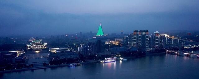A night view of Pyongyang from the Juche Tower observatory in June 2018. The building illuminated by green lights is the 105-story Ryugyong Hotel
