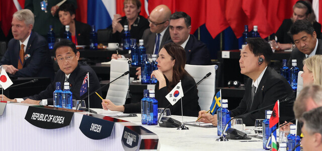 President Yoon Suk-yeol (right) listens to speeches by state leaders at the NATO summit for allies and partners in Madrid, Spain, on June 29. (Yonhap News)
