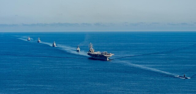 Warships participating in trilateral anti-submarine warfare exercises by South Korea, the US, and Japan are seen conducting maneuver drills in the international waters of the East Sea on Sept. 30. From right: the Aegis-equipped destroyer USS Benfold (DDG), the Korean Navy destroyer ROKS Munmu the Great (DDH-II), the US nuclear-powered aircraft carrier USS Ronald Reagan (CVN), the Japanese destroyer JS Asahi (DD), and the US cruiser USS Chancellorsville (CG). The warships are led by the US nuclear-powered submarine USS Annapolis (SSN). (Republic of Korea Navy)