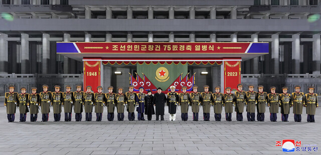 North Korean leader Kim Jong-un and daughter Kim Ju-ae stand for a photo with high-ranking party officials during the nighttime military parade in Pyongyang’s Kim Il-sung Square held for the 75th founding anniversary of the Korean People’s Army on Feb. 8. (KCNA/Yonhap)