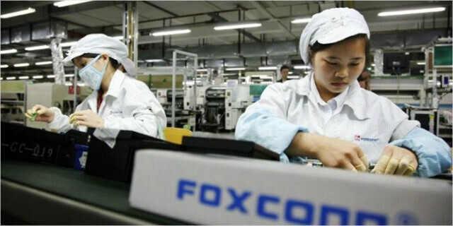 Workers at Foxconn, Apple’s biggest partner, assemble products on a line. (Yonhap)