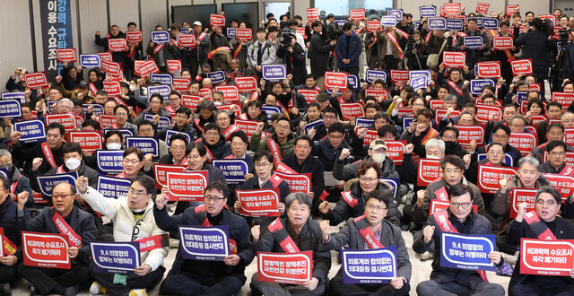 Those in attendance at an expanded meeting of representatives of physicians across Korea held at the headquarters of the Korean Medical Association on Feb. 25, 2024, chant slogans and hold signs opposing the increase in medical school admissions. (Kim Jung-hyo/The Hankyoreh)