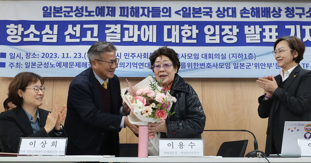 2023년 12월23일 오후 서울 서초구 민주사회를위한변호사모임 사무실에서 열린 ‘일본군 성노예제 피해자’들의 일본 정부 상대 손해배상 청구 소송 항소심 선고 결과에 대한 기자회견에서 원고로 참여한 이용수 선생(왼쪽 셋째)이 축하 꽃다발을 받으며 웃고 있다. 한겨레 백소아 기자