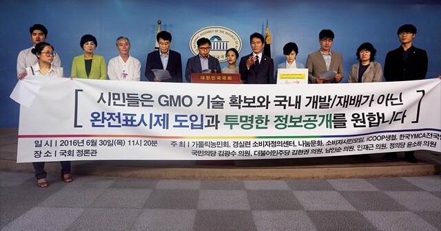 윤소하 정의당 의원(오른쪽 다섯 번째)이 6월30일 서울 여의도 국회 정론관에서 기자회견을 열어 “독소조항을 가진 현행 식품위생법으로는 GMO로부터 국민의 안전을 지킬 수 없다”며 GMO 완전표시제법 발의 계획을 밝히고 있다. 이날 기자회견에는 농민단체, 소비자단체, 시민단체 등도 함께했다. 윤소하 의원실 제공
