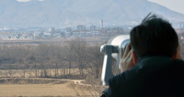 A woman in her 40s who wanted to return to North Korea in order to see her son has been arrested and charged with violating the National Security Act for allegedly sending 130 tons of rice to the North Korean State Security Ministry. The photo shows a man looking at North Korea’s Peace Village across the border from the Daeseong Town Hall in Paju