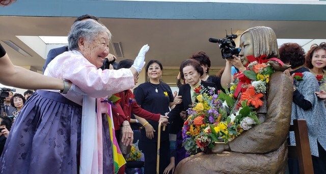 Former comfort woman Gil Won-ok poses next to the comfort woman statue during its unveiling ceremony in Annandale, Virginia, on Oct. 27.
