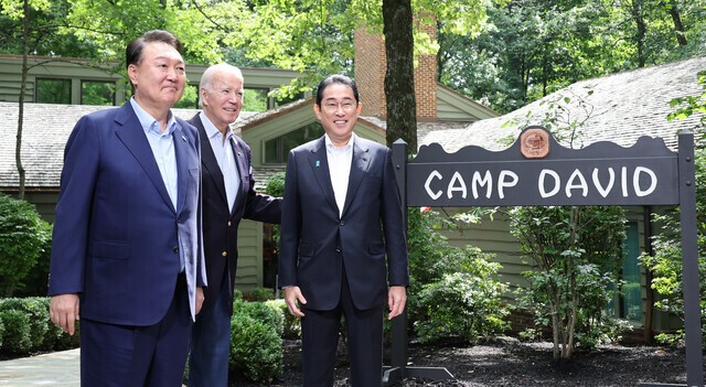 South Korean President Yoon Suk-yeol, US President Joe Biden, and Japanese Prime Minister Fumio Kishida stand for a photo outside the Aspen Lodge at Camp David, the US presidential retreat in Maryland, on Aug. 18 ahead of their trilateral summit. (Yonhap)
