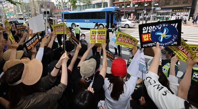 16개월 된 입양아 정인이를 학대해 숨지게 한 혐의를 받는 양부모의 1심 선고 공판이 열린 지난 5월14일 오전 서울 양천구 서울남부지법 앞에서 시민들이 양모 장씨가 탄 것으로 보이는 호송차를 향해 손팻말을 들고 항의하고 있다. 연합뉴스