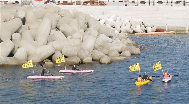 Activists on kayaks demonstrate against the construction of a naval base at Gangjeong Harbour on Jeju Island