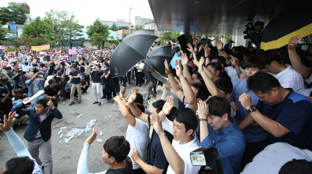 사드(THAAD·고고도미사일방어체계) 배치 지역으로 결정된 경북 성주 주민들이 7월15일 성주군청에서 사드 관련 설명을 하러 온 황교안 국무총리 일행에게 물병을 던지자, 경찰과 경호원들이 우산으로 막고 있다. 연합뉴스