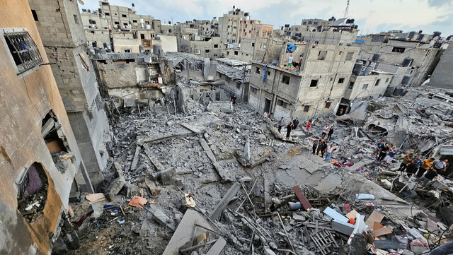 2023년 10월19일 팔레스타인 땅 가자지구 북부 자발리아 지역에서 이스라엘군 공습으로 폐허가 된 건물 주변에 주민들이 모여 있다. REUTERS 연합뉴스