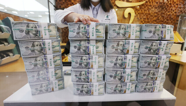 A worker at KEB Hana Bank in central Seoul organizes US dollars on April 28, when the won-to-dollar exchange rate hit 1,272.5 won. (Yonhap News)