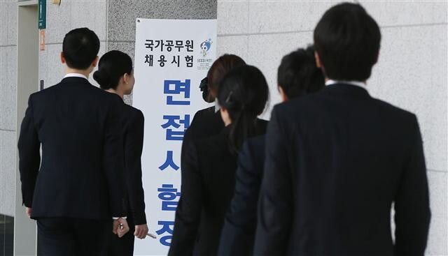 Test-takers seeking to become grade-five civil servants enter the test area at the aT Center in Seoul‘s Seocho district