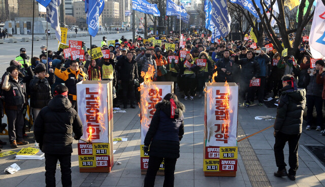 Members of the Korean Confederation of Trade Unions (KCTU) burn effigies reading