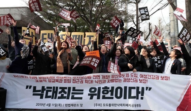 Civic groups opposed to the criminalization of abortion celebrate after the Constitutional Court’s ruling that the ban on abortion is unconstitutional on Apr. 11. (Park Jong-shik