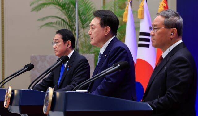 South Korean President Yoon Suk-yeol (center) speaks at a joint press conference held after a trilateral summit with Prime Minister Fumio Kishida of Japan (left) and Chinese Premier Li Qiang (right) at Seoul’s Blue House on May 27, 2024. (courtesy of presidential office) 