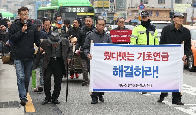  elderly recipients of basic living security and the Coalition for Guaranteeing the Basic Pension to Elderly People in Poverty march toward the Blue House from Gyeongbokgung Palace Station to demand that the Blue House address the issue of pension benefits being subtracted from their living security. (Park Jong-shik