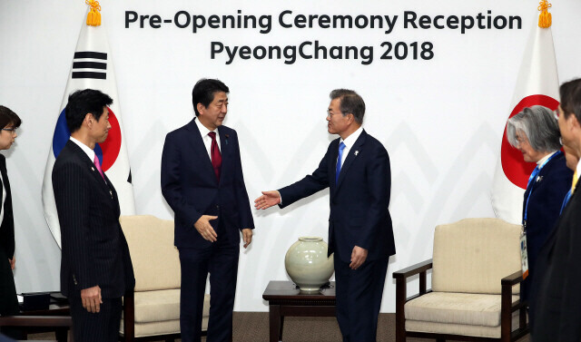 Then-Prime Minister Shinzo Abe of Japan and South Korean President Moon Jae-in greet each other during the pre-opening ceremony reception for the PyeongChang Winter Olympics at a resort in Yongpyong, Gangwon Province, on Feb. 9, 2018. (Blue House photographers’ pool)