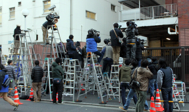 Reporters gathered outside the rear entrance to Kojimachi Police Station in Tokyo