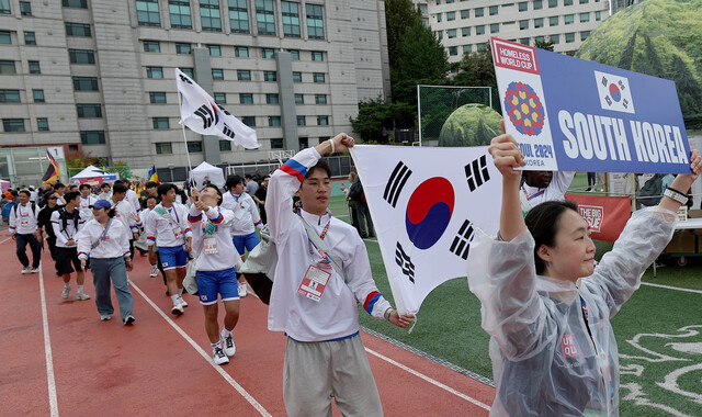 2024년 9월21일 서울 성동구 한양대 대운동장에서 열린 서울 2024 홈리스월드컵 개막식을 앞두고 한국 대표팀 선수들이 행진하고 있다. 가장 앞에 주장 김성준과 포시 완지가 태극기를 들고 걷고 있다. 이종근 선임기자 root2@hani.co.kr