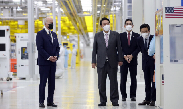 US President Joe Biden (left) and South Korean President Yoon Suk-yeol (center) receive a tour from Samsung Electronics’ Vice Chairman Lee Jae-yong (center back) around the company’s chip factory in Pyeongtaek, Gyeonggi Province, on May 20, 2022. (pool photo)