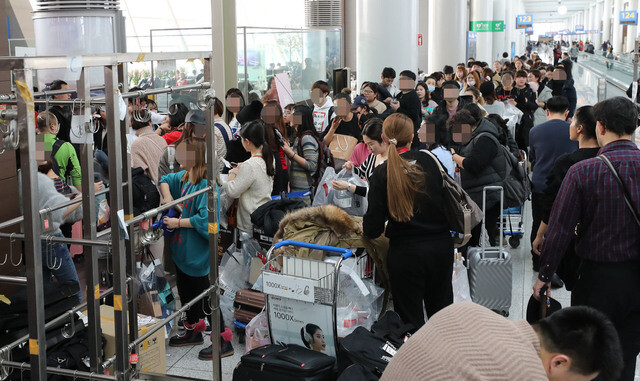 Chinese tourists form a crowd at the duty free goods delivery area of Incheon International airport on Dec. 22. (Yonhap News)