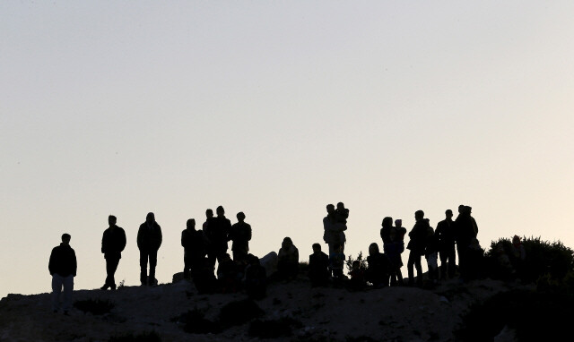 11월4일 터키 서부 체시메 해안 언덕에 올라 그리스 섬으로 출항하는 이들을 지켜보는 난민들.  REUTERS