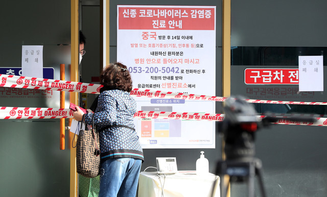 A family member of a confirmed novel coronavirus patient delivers personal items to the hospital where the patient is being quarantined at Kyungpook National University Hospital in Daegu on Feb. 19. (Yonhap News)