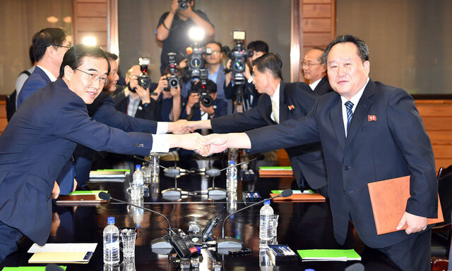 South Korean Unification Minister Cho Myoung-gyon (left) shakes hands with Ri Son-gwon
