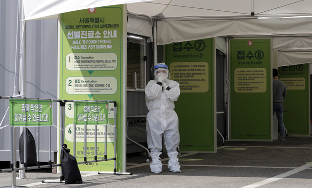 A medical worker at a walk-thru screening center in the parking lot of Seoul Sports Complex on Apr. 3. (Kim Hye-yun, staff photographer)