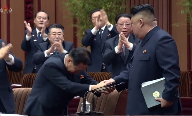 North Korean leader Kim Jong-un shakes hands with Choe Ryong-hae