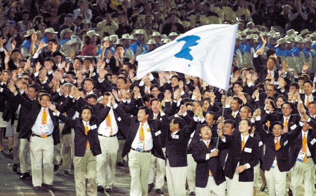 South and North Korean athletes make a joint entrance to the Sydney Olympic games in 2000 led by South Korean women’s basketball captain Jung Eun-soon (center right) and North Korean judo captain Park Jeong-cheol (waving the Korean Peninsula flag).