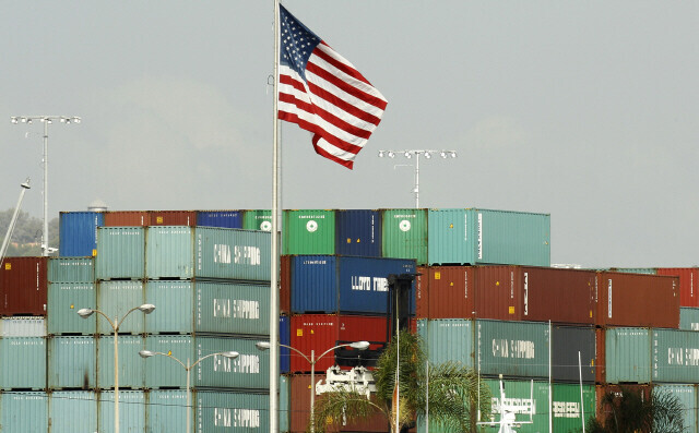 An American flag flies at the Port of Los Angeles in California in December 2016, where shipping containers filled with Chinese goods wait to be unloaded. Trump slapped a 25% tariff on Chinese goods two years later, claiming that they were taking away jobs from Americans. (Reuters/Yonhap)