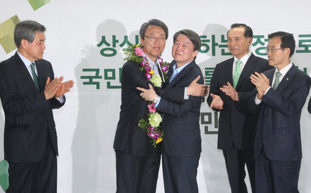 People’s Party leader Ahn Cheol-soo (center) congratulates Kim Sung-shik
