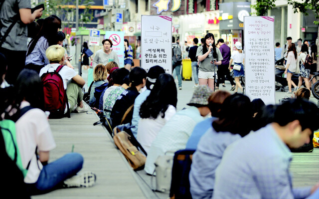 Women listen during an “open air speakers corner opposing violence against women” in Seoul’s Sinchon area