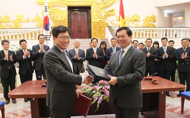  Industry and Energy Yoon Sang-jik (left) and Vietnamese Minister of Industry and Trade Vu Huy Hoang exchange documents after signing a bilateral free trade agreement in Hanoi