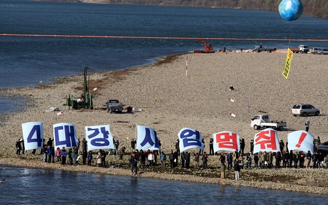 2009년 11월 경기도 여주 남한강 이포보 가물막이 공사장에서 시민단체 회원들이 대형 펼침막을 들고 이명박 대통령의 4대강 죽이기를 저지하는 시위를 벌이고 있다. 한겨레 김명진 기자