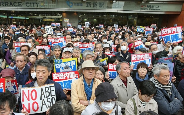 3월18일 일본 도쿄 신주쿠역 앞에서 시민들이 아베 신조 내각의 퇴진을 요구하고 있다. 연합뉴스